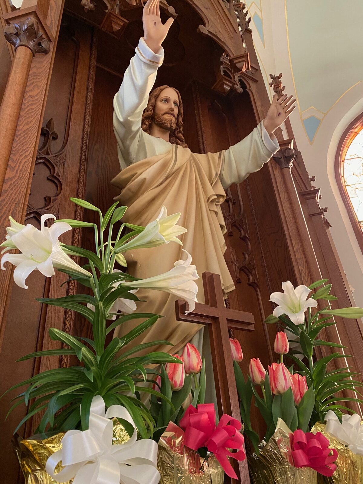 Risen Christ statue above the altar at St. John — the new life given in Baptism